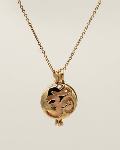 Gold Scent Locket necklace with a delicate chain and a round pendant featuring an intricate cut-out design, ideal for holding aromatherapy scents close.