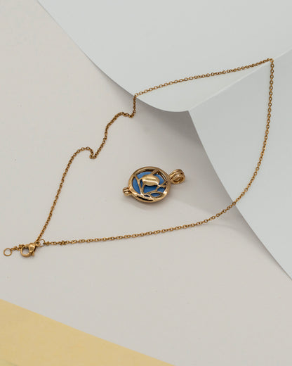 Gold Scent Locket featuring a delicate gold chain and a round pendant with a blue enamel design, perfect for wearing as an aromatherapy necklace.