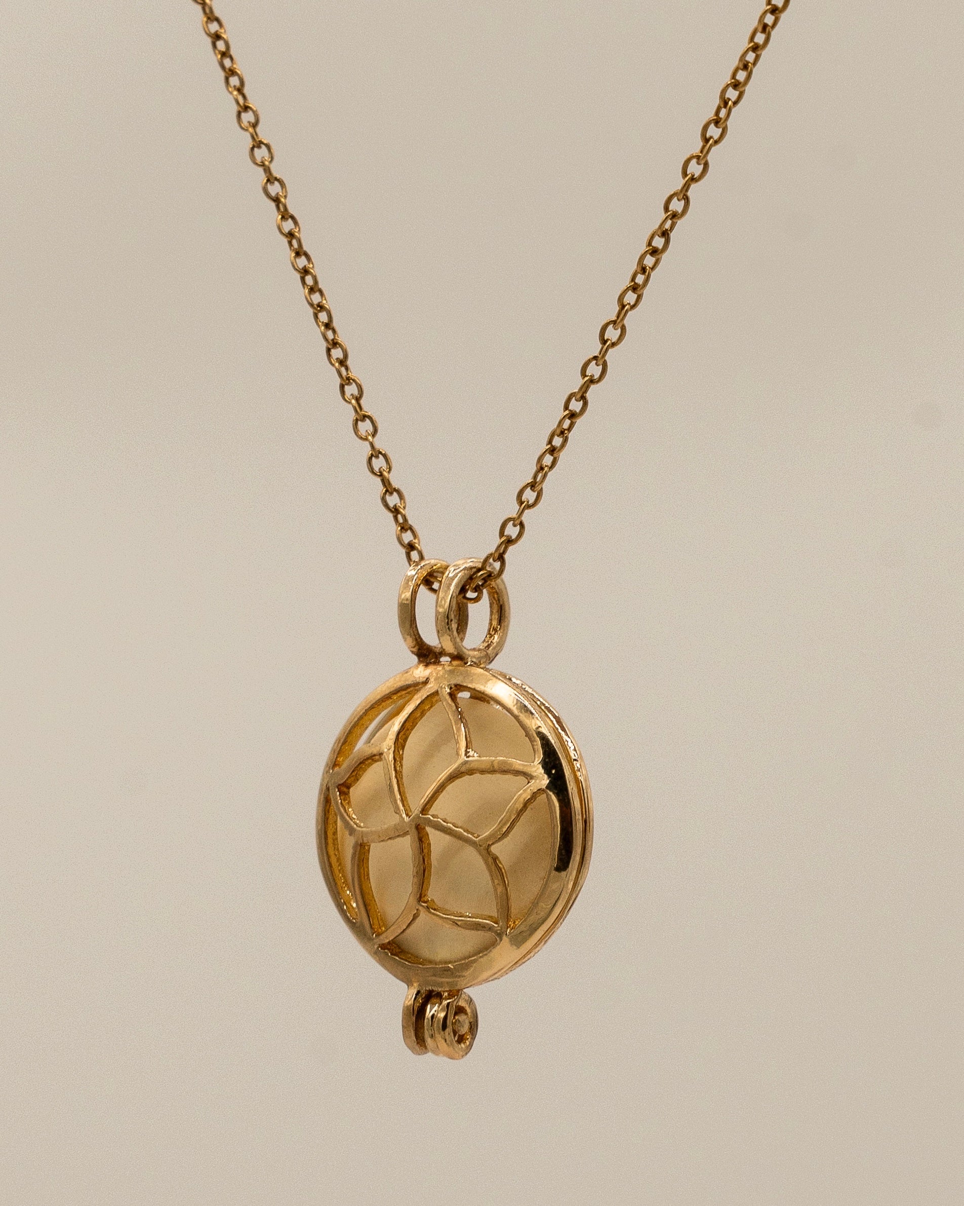 Gold Scent Locket with intricate floral design on a delicate chain, crafted for holding aromatic oils to enhance aromatherapy and personal scent experience.