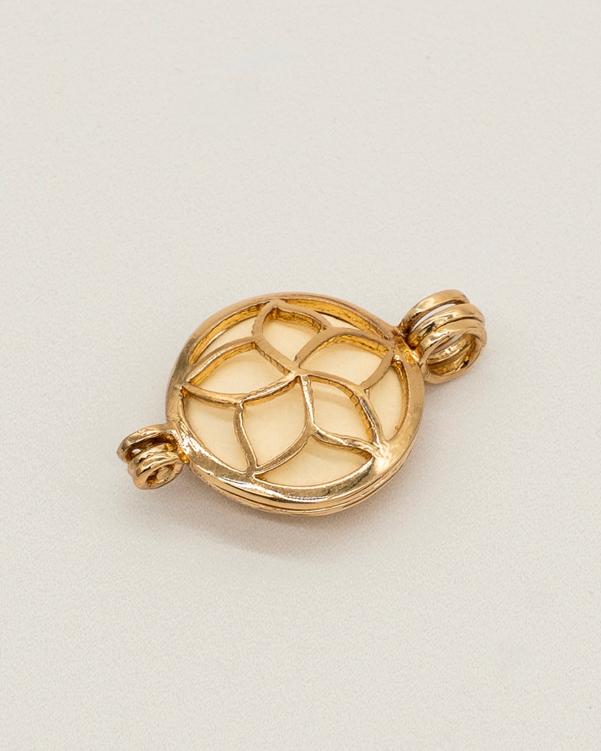 Gold Scent Locket featuring an intricate floral-inspired openwork design, crafted in polished gold-tone metal for use as an elegant aromatherapy necklace accessory.