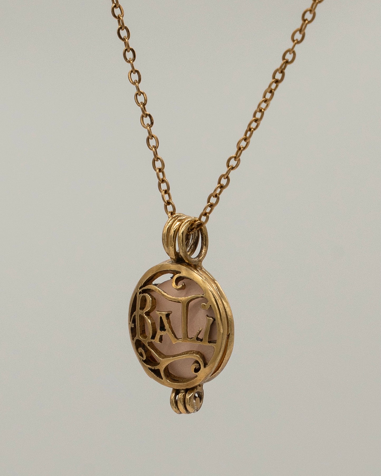Gold Scent Locket pendant necklace with intricate filigree design, crafted in warm gold tone, perfect for holding a small aromatic keepsake.