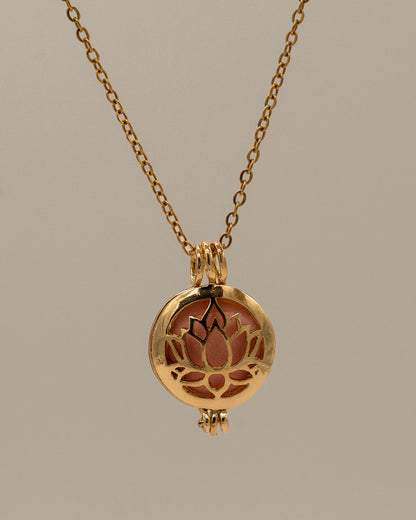 Gold Scent Locket featuring a delicate gold chain and a round pendant with a lotus flower cutout design, designed for aromatherapy use.