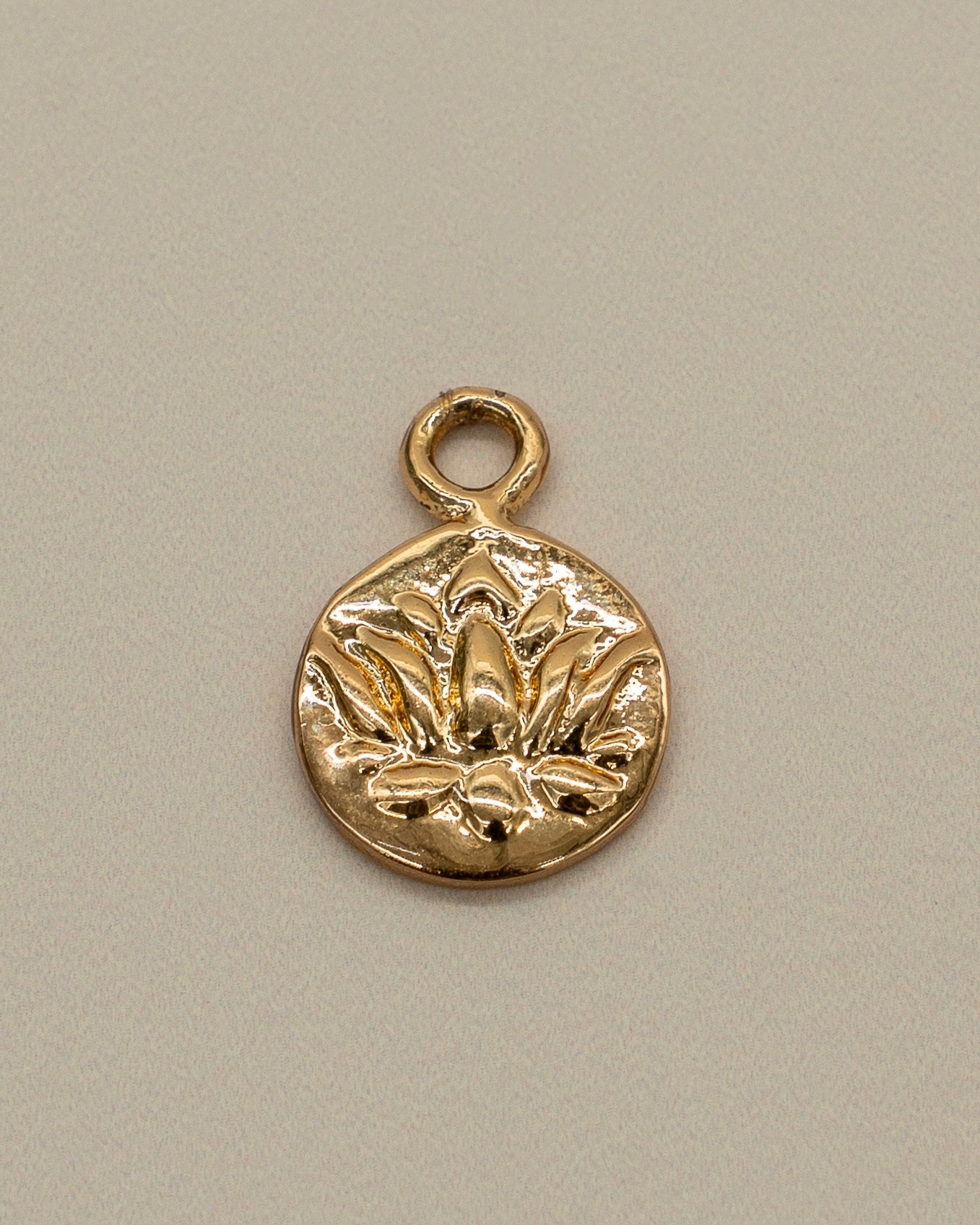 Small gold charm with an engraved floral design, intended as a decorative piece for a Charm Bracelet.