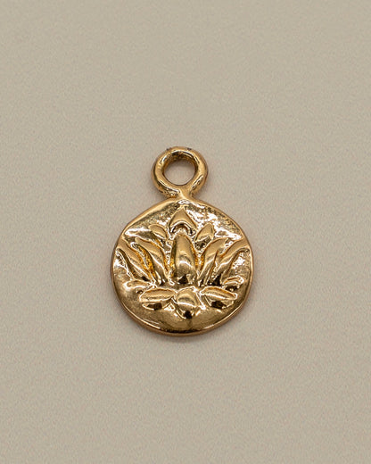 Small gold charm with an engraved floral design, intended as a decorative piece for a Charm Bracelet.