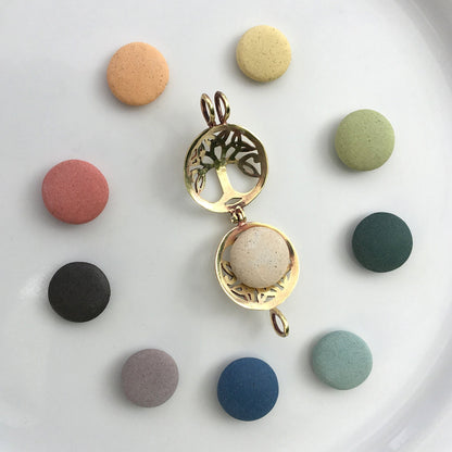 Gold tree-shaped pendant with a beige sphere on a white background with colorful round stones.