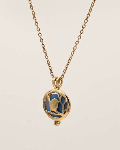 Gold Scent Locket featuring an intricate gold pendant with a blue interior stone on a delicate gold chain, designed as an aromatherapy necklace for a subtle fragrant experience.