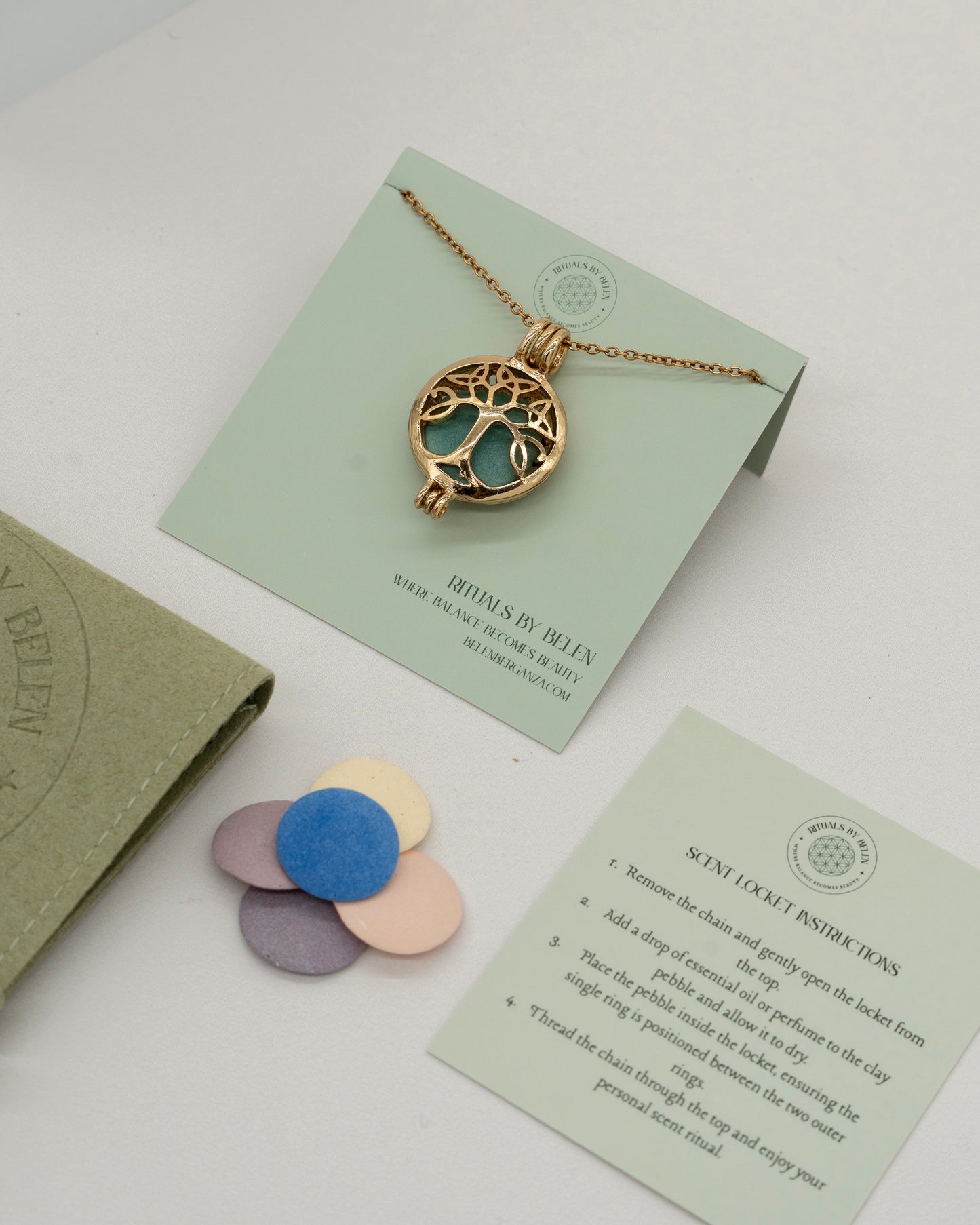 Gold Scent Locket with intricate tree design pendant on chain, displayed with colorful scent pads and instruction card for aromatherapy use.