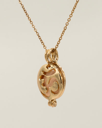 Close-up of a delicate Gold Scent Locket necklace featuring an intricate openwork design on a fine chain, perfect for aromatherapy use.
