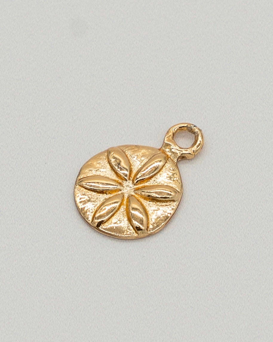 Gold sand dollar pendant on a light gray background